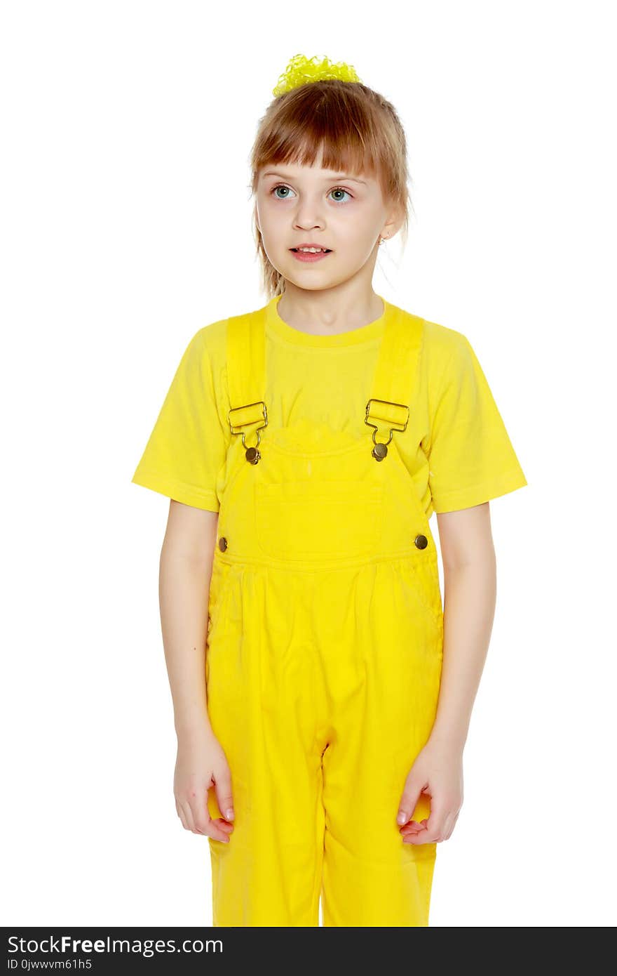 Girl with a short bangs on her head and bright yellow overalls.