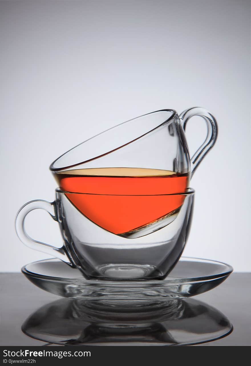 Glass cups of tea on saucer, good concept the idea, on gradient background.