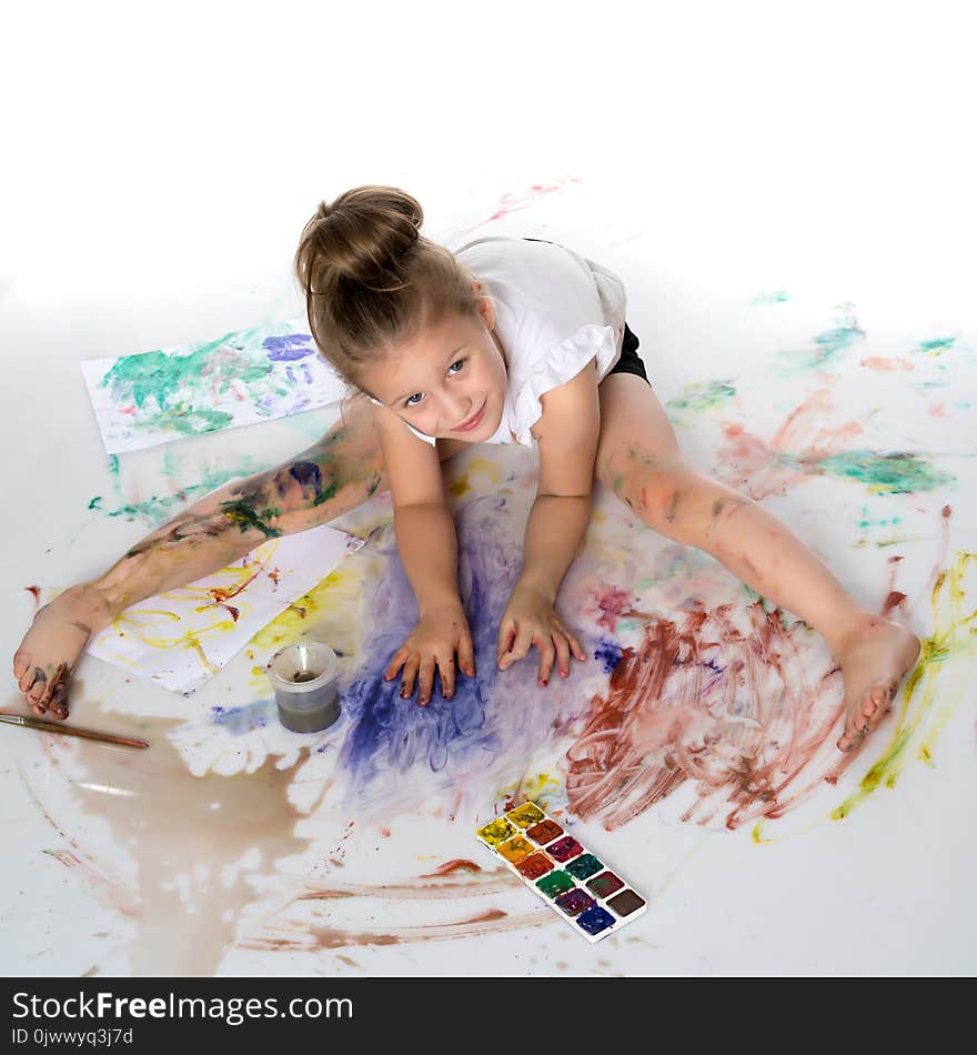 A little girl draws paints on her body. The concept of children`s creativity, education and school. on white background.