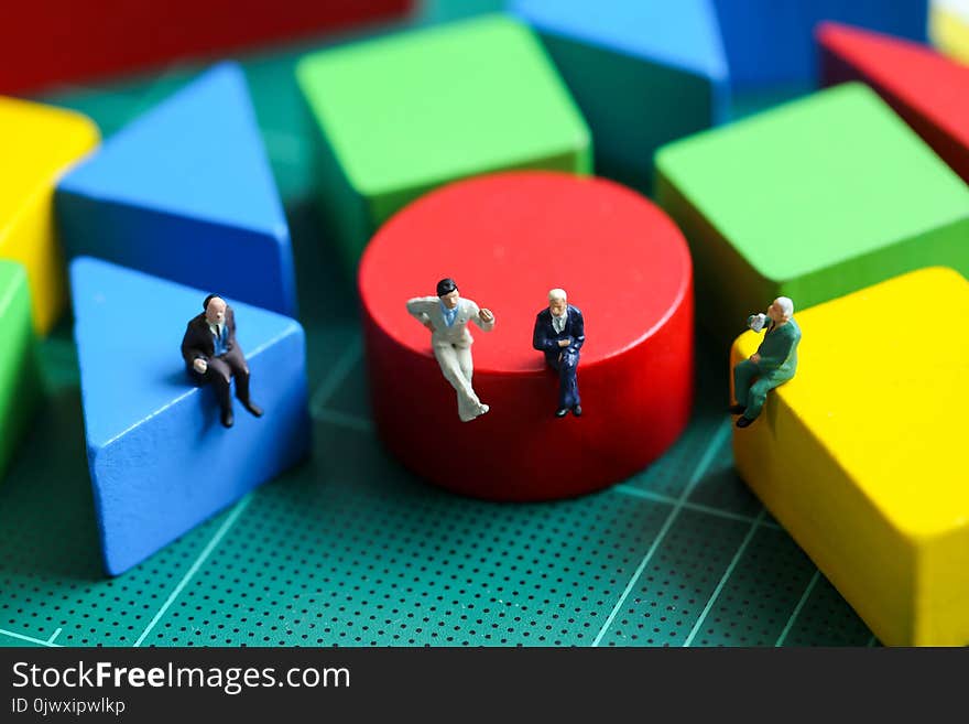 Miniature people : Businessman sitting with wooden block toy, Education and Business concept.