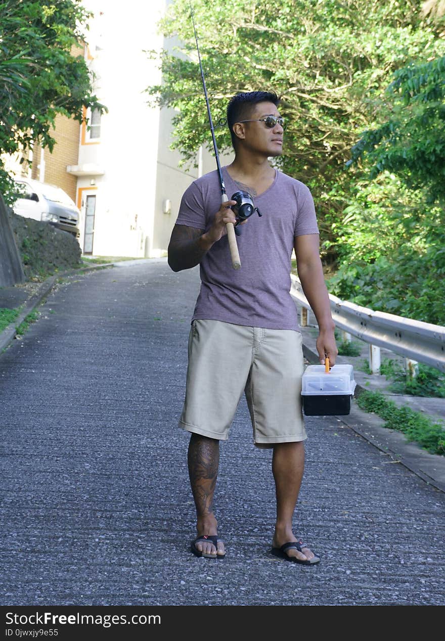 Man on seawall on vacation in Japan with T shirt going fishing. Man on seawall on vacation in Japan with T shirt going fishing