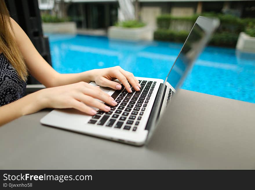 Woman Fingers typing on computer keyboard. Close up portrait of hands pressing buttons on laptop at sunny day swimming pool. concept of business freelance working, new technologies. Woman Fingers typing on computer keyboard. Close up portrait of hands pressing buttons on laptop at sunny day swimming pool. concept of business freelance working, new technologies