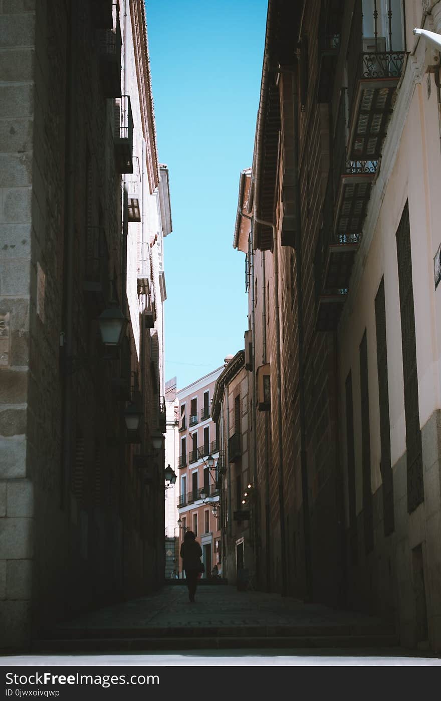 Person Walking Between of Houses