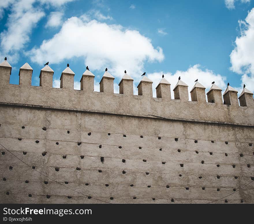 Brown Concrete Castle Wall Under Cumulos Clouds