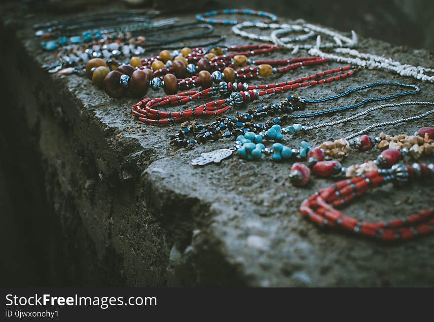 Close Up Photo of Beaded Accessories on Gray Surface