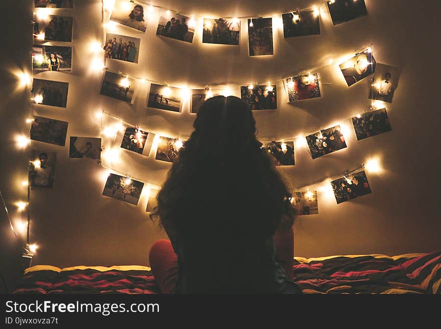 Woman Watching Photo Collection With String Lights