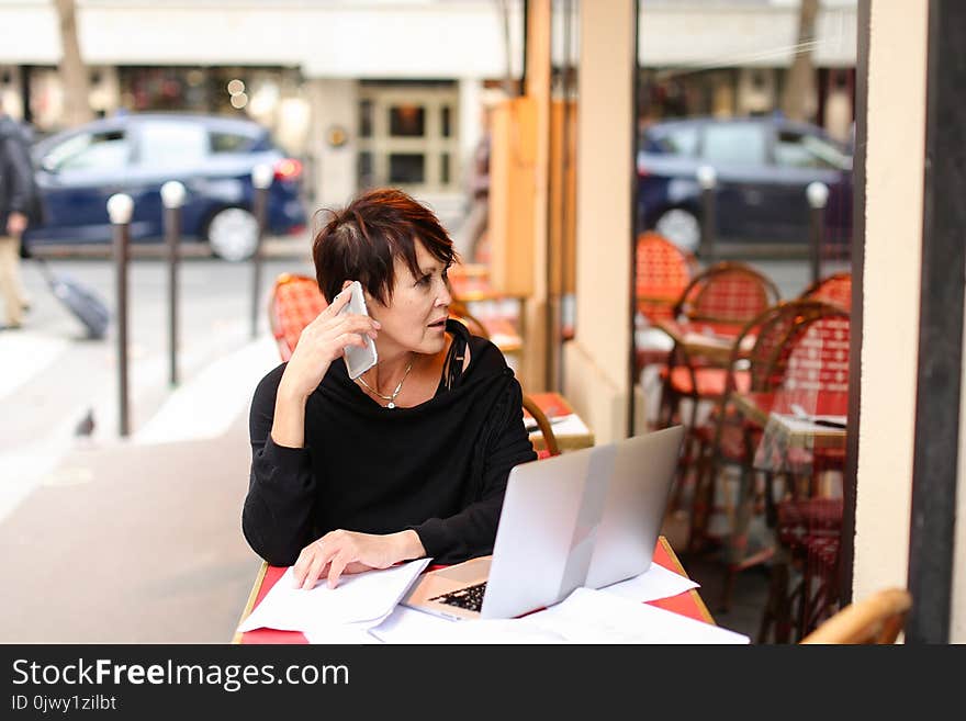 female client of co-working working at table with laptop and make purchases by credit card. Aged lady sitting near desk littered with papers glasses laying on sheet. Woman hold card and enters payment information in computer. Concept of easy shopping with gadgets and internet. female client of co-working working at table with laptop and make purchases by credit card. Aged lady sitting near desk littered with papers glasses laying on sheet. Woman hold card and enters payment information in computer. Concept of easy shopping with gadgets and internet.