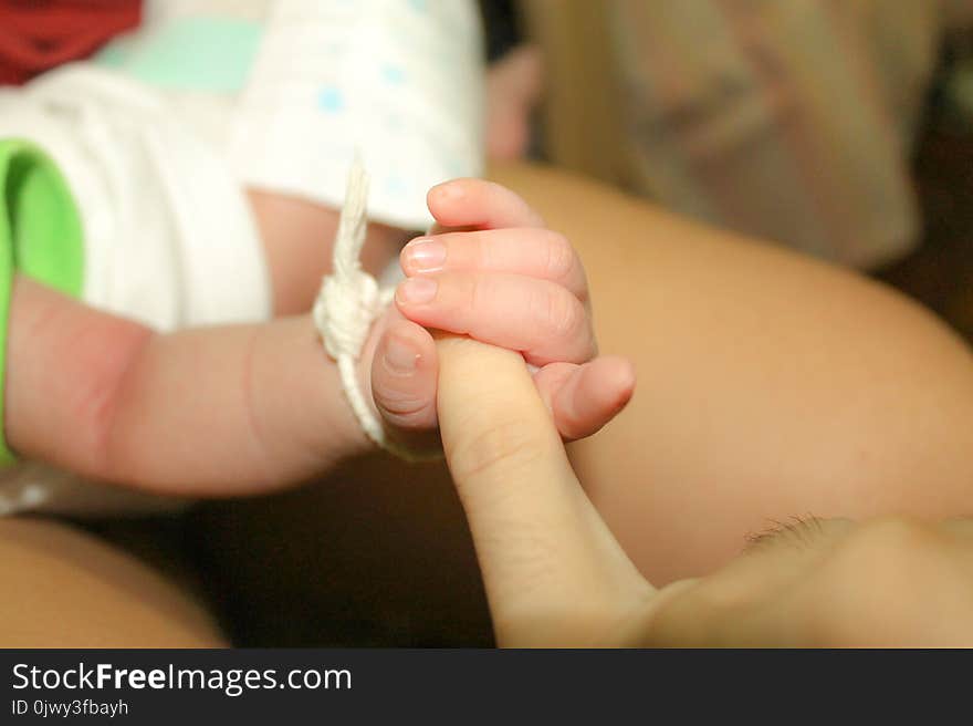 Infant holding father`s finger. 2 months old baby holding his dad `s left little finger.