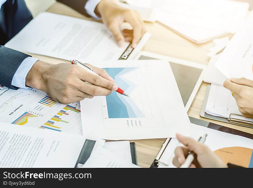 Close-up of business team using pen with financial diagram and digital tablet