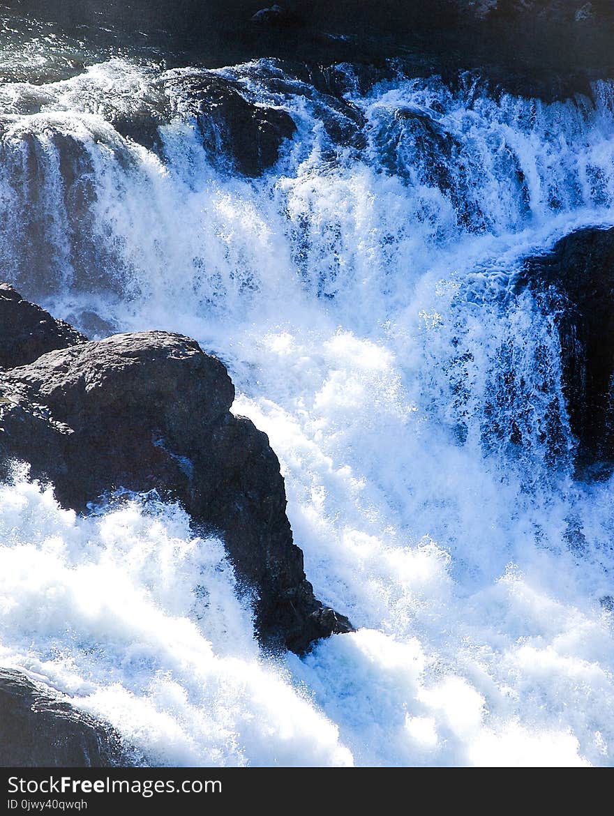 A small waterfall cascading through large boulders on it`s way to the ocean. A small waterfall cascading through large boulders on it`s way to the ocean