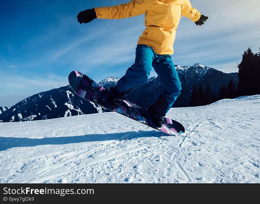Snowboarder snowboarding in winter mountains
