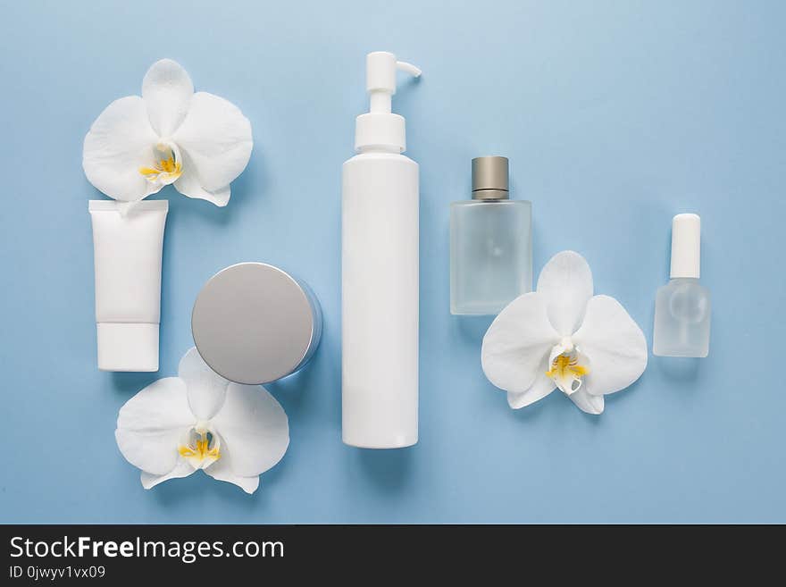 White cosmetic bottles on a blue background. flat lay