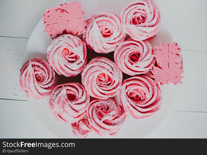 Marshmallow from cranberry, pink. Pink flowers. Homemade zephyr. On a white wooden background.