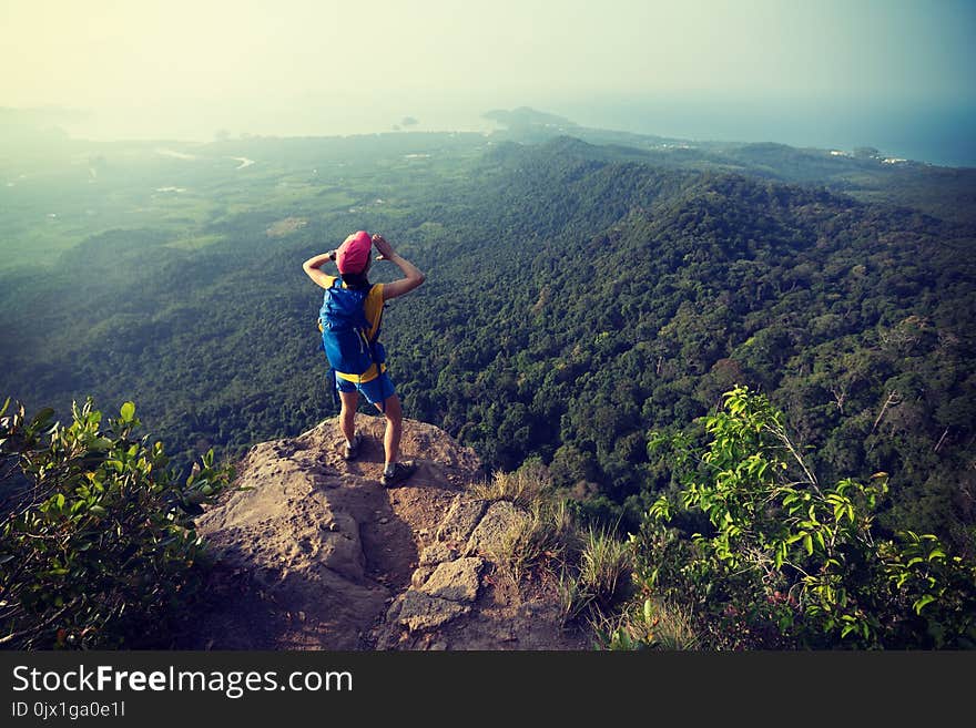 Woman hiker shouting on mountain peak cliff edge