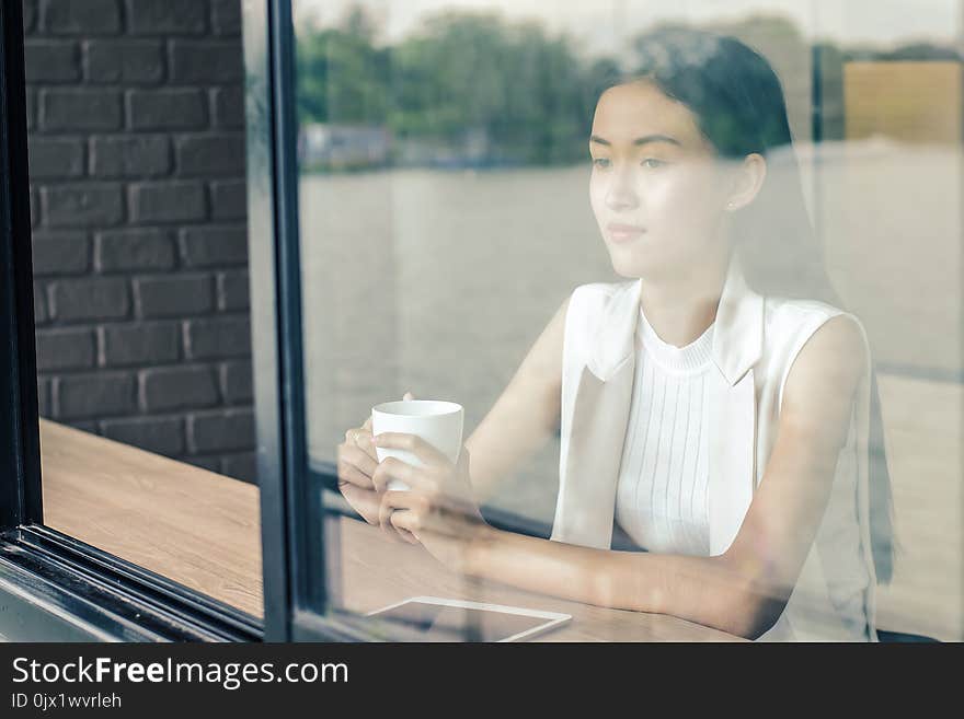 Young woman drinking relaxing coffee in coffee shop