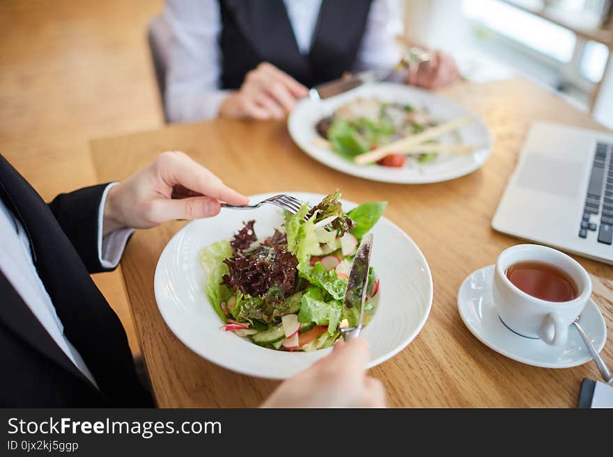 Close-up of business people eating salad at restaurant