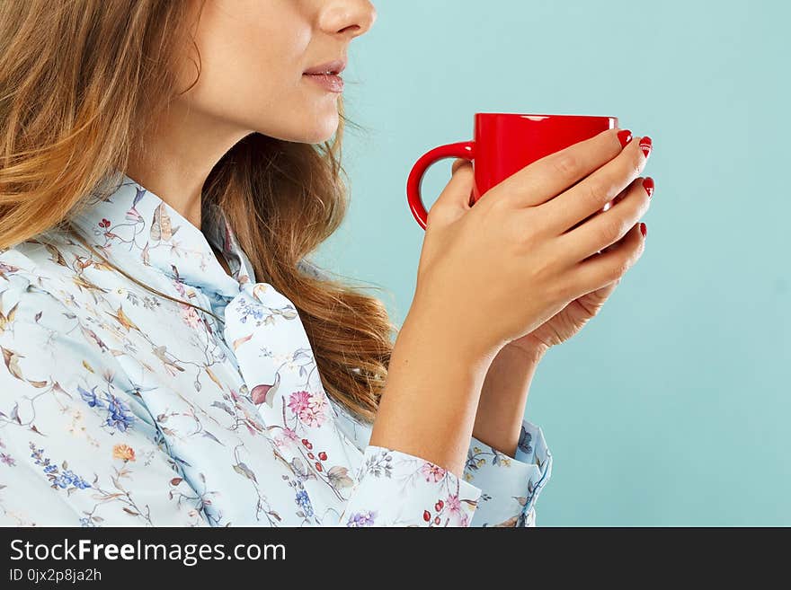 Young Woman Holding A Cup Of Tea Or Coffee Over Blue Background