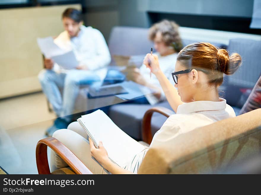 One of young managers sitting in armchair and making plan of project or thinking of ideas. One of young managers sitting in armchair and making plan of project or thinking of ideas