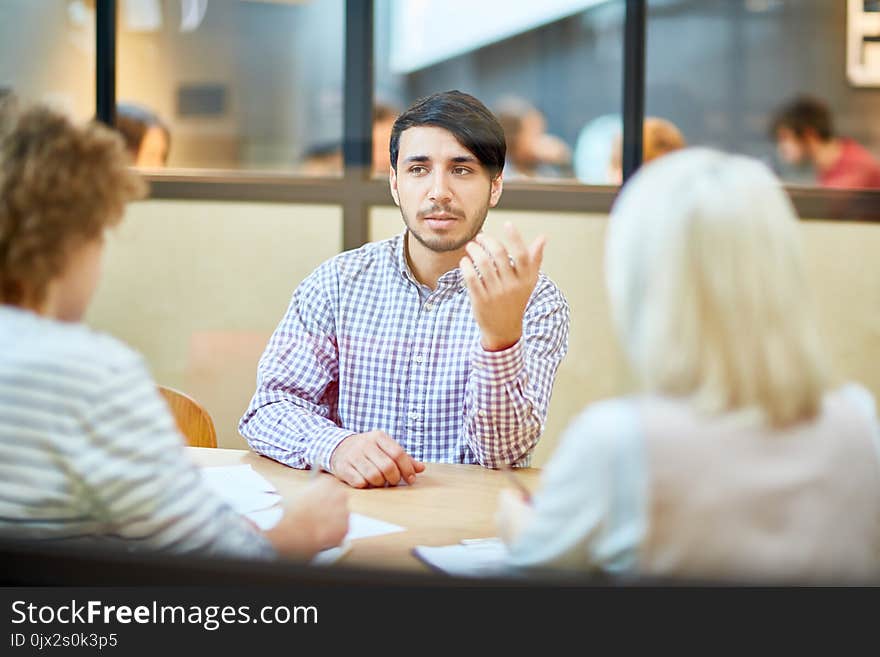 Young applicant explaining his objectives while talking to employers during interview in office. Young applicant explaining his objectives while talking to employers during interview in office