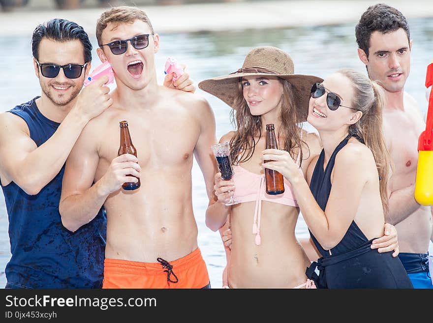 Group of friends making party in the pool and Drinking beverage