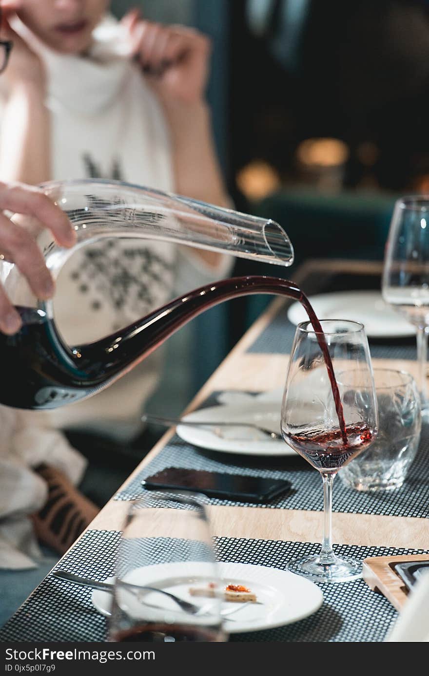 Sommelier At Wine Tasting Pouring Red Wine From Decanter Into Glass At Wine Tasting