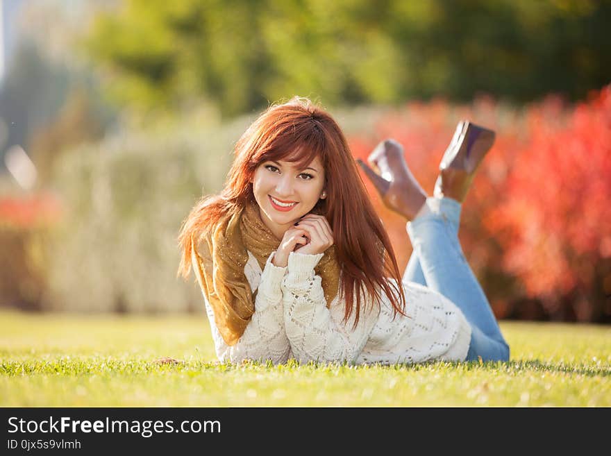 Young pretty woman relaxing in the park. Nature beauty, colorful field with flowers. Outdoor lifestyle. Freedom concept. Woman in summer field