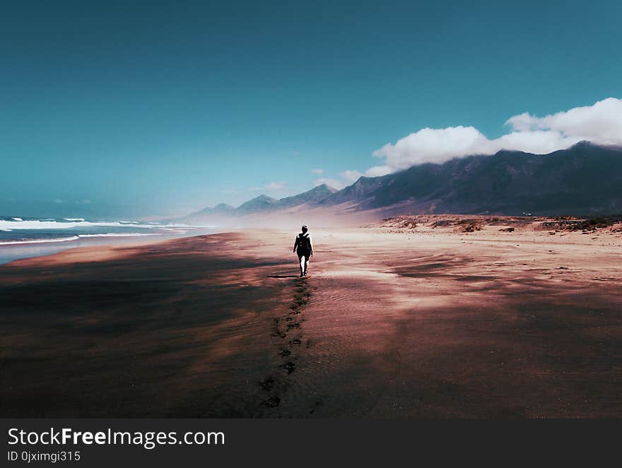 Photo of Person Walking on Deserted Island