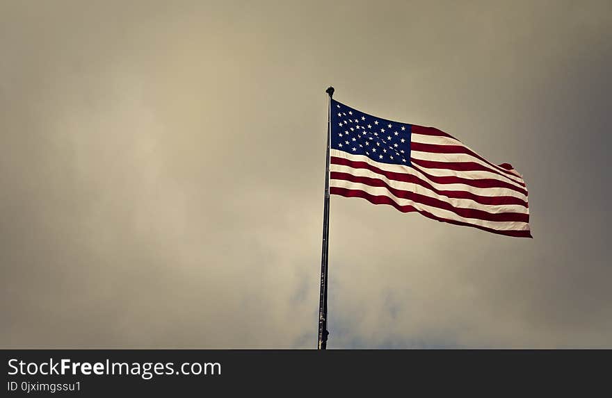 Photo of Cloudy Skies over American Flag