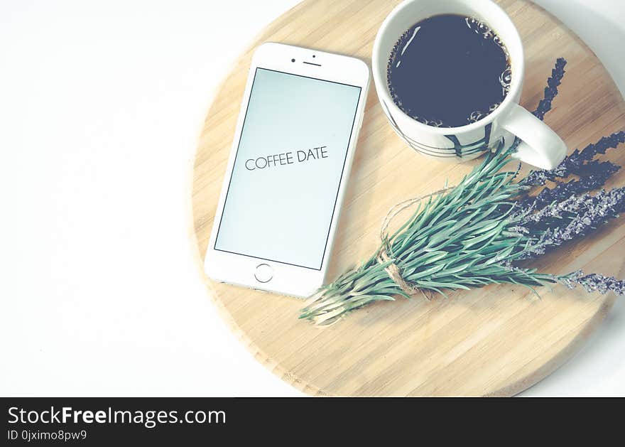 Iphone Beside Coffee And Flower