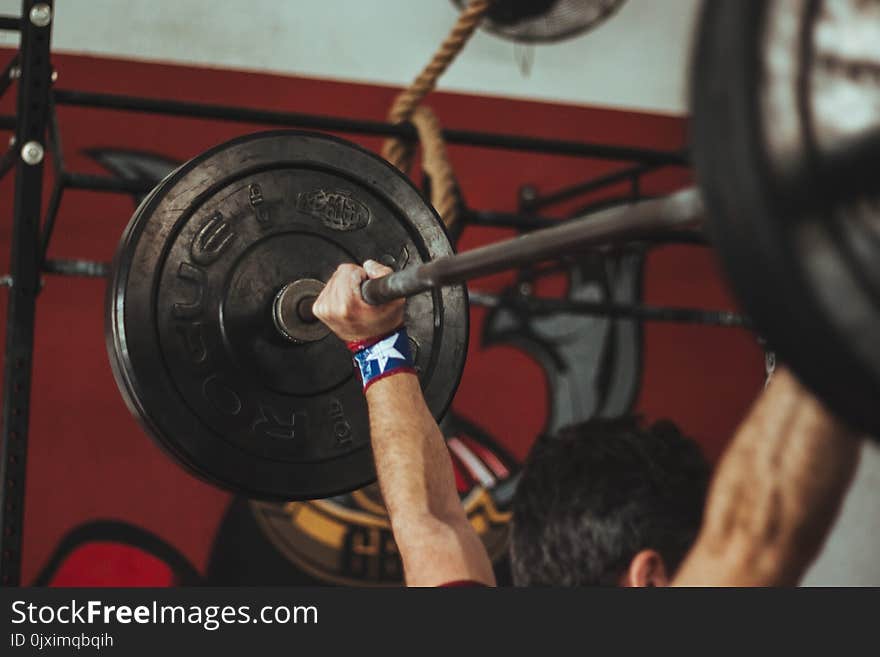 Person Carrying Black Barbell