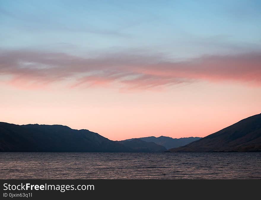 Body of Water With Mountains on Side