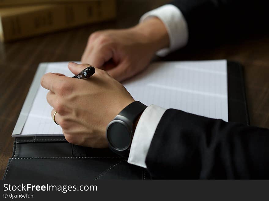 Person on Black Suit Jacket Writing on White Paper