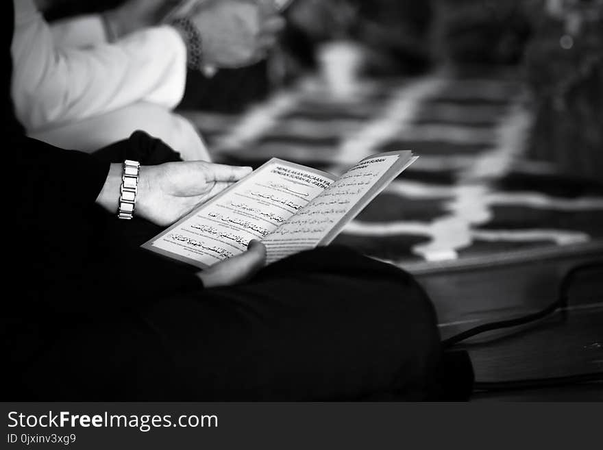 Grayscale Photography of a Person Holding Book