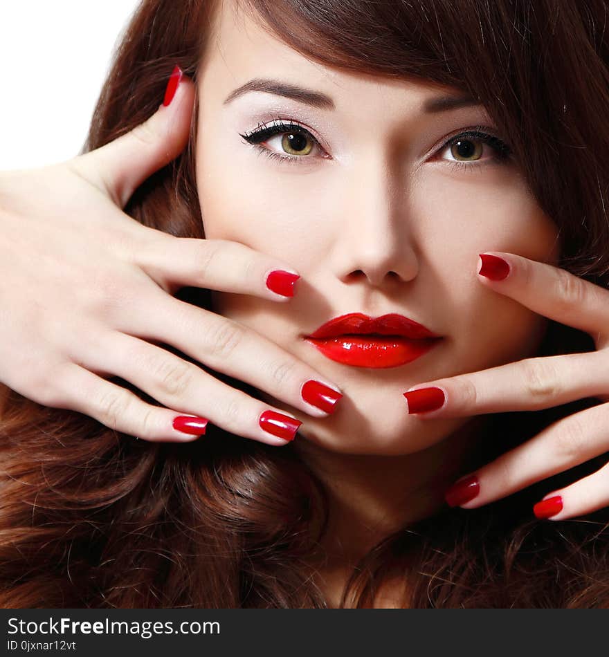 Young woman portrait with long hair, red lipstick and manicure, studio shot