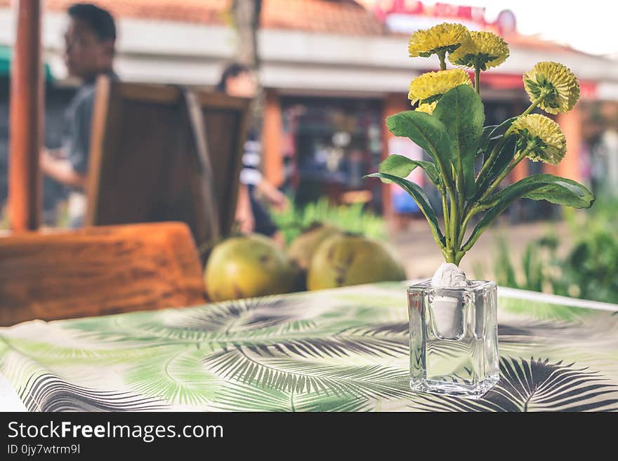 Yellow Flower Arrangement in Vase on Top of Table