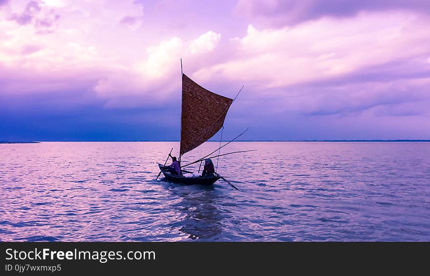 Person in Sailboat on Body of Water during Golden Hour