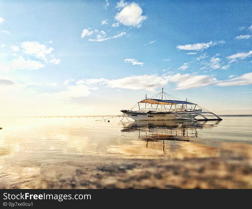 White Boat on Sea during Sunrise