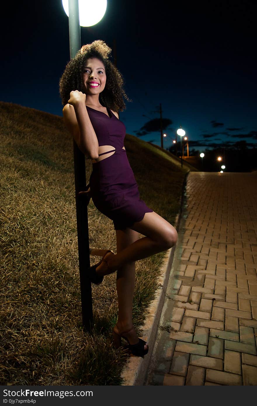 Woman Wearing Purple Dress Behind Gray Pole Photo