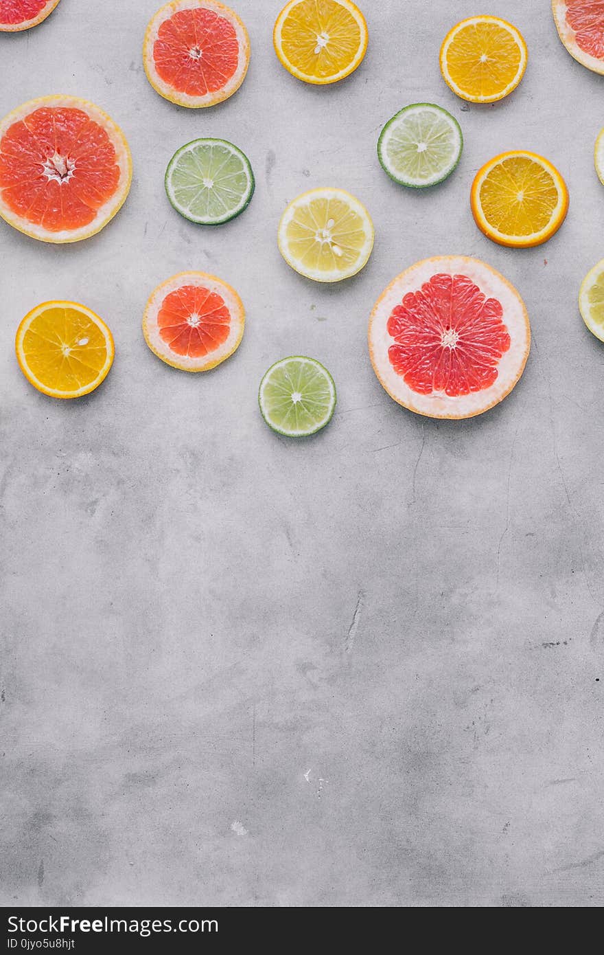 Top view sliced citrus fruit on light background with border. Flat lay. Summer background. Top view sliced citrus fruit on light background with border. Flat lay. Summer background