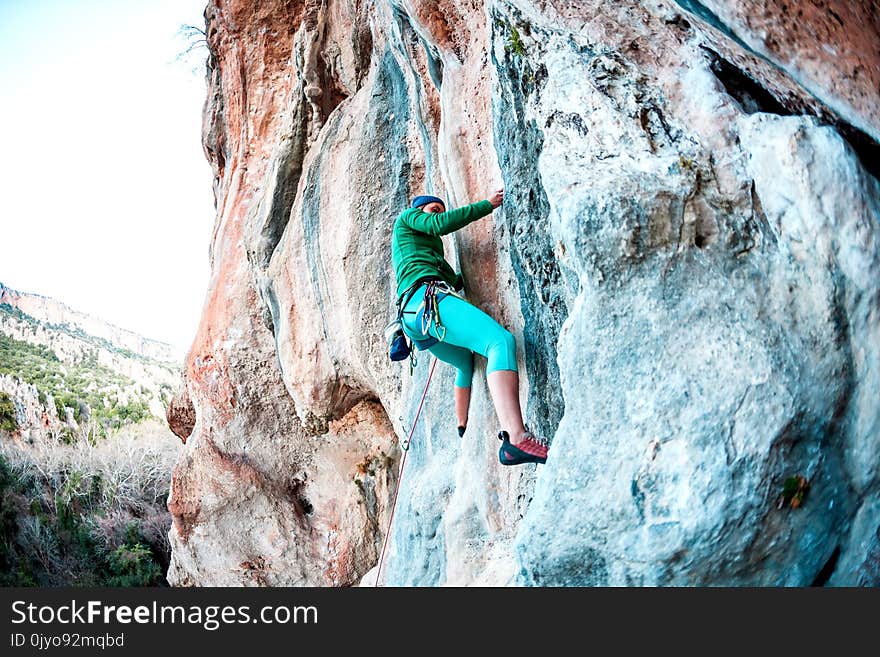 A woman climbs the rock.