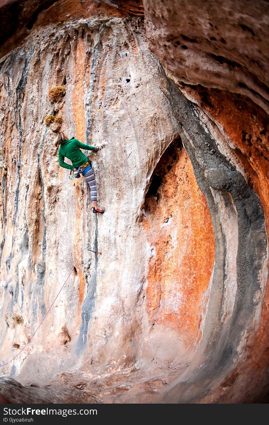 A woman climbs the rock. Climbing in nature. Fitness outdoors. Active lifestyle. Extreme sports. The athlete trains on a natural relief.