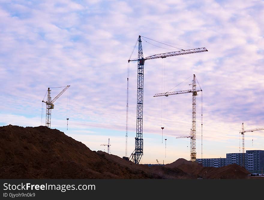 Crane and building construction site at sunset, sunrise