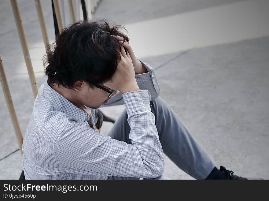 Frustrated stressed young Asian business man feeling disappointed or exhausted with job at outside office.