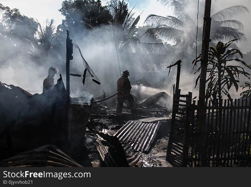 Silhouette of Fireman Holding Hose