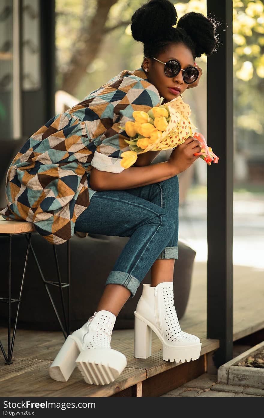 Woman Wearing White-green-yellow Geometric Sleeved Shirt, Blue Denim Pants and White Block Heeled Booties