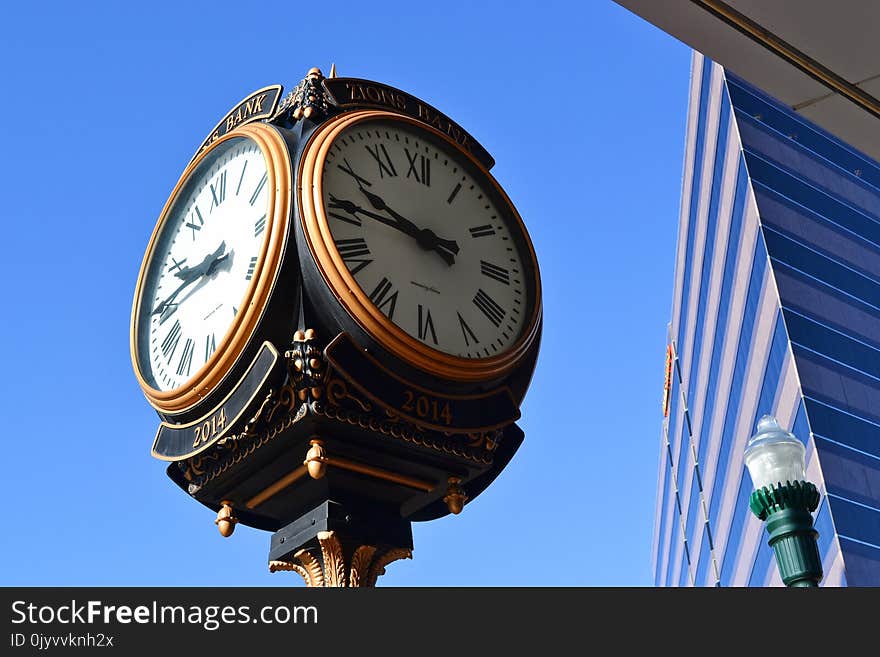 Close-up Photo of Street Clock Near Tall Building