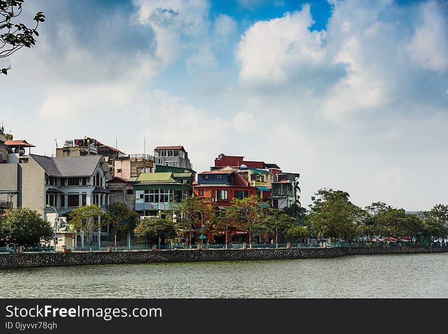 Assorted-color Buildings Near Water and Trees