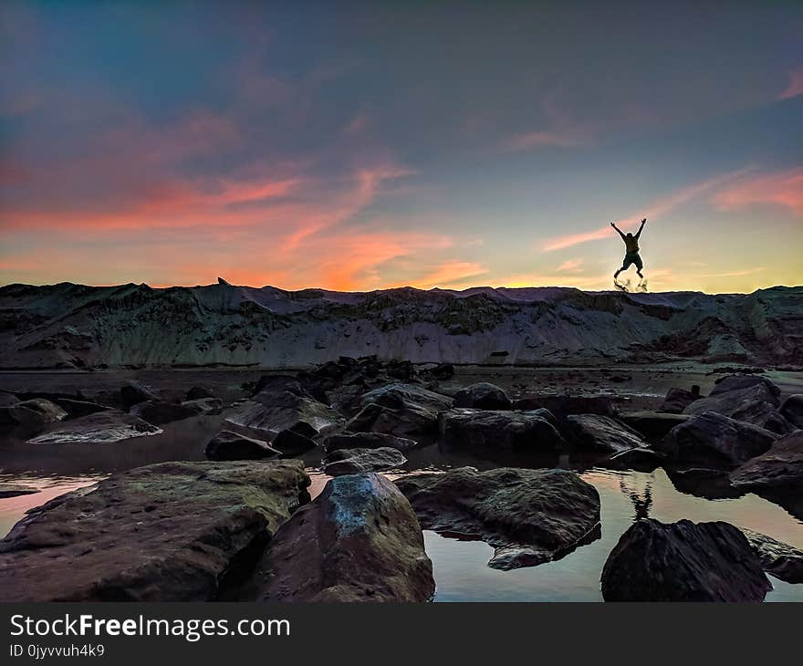 Person Jumping on Mountain Photo