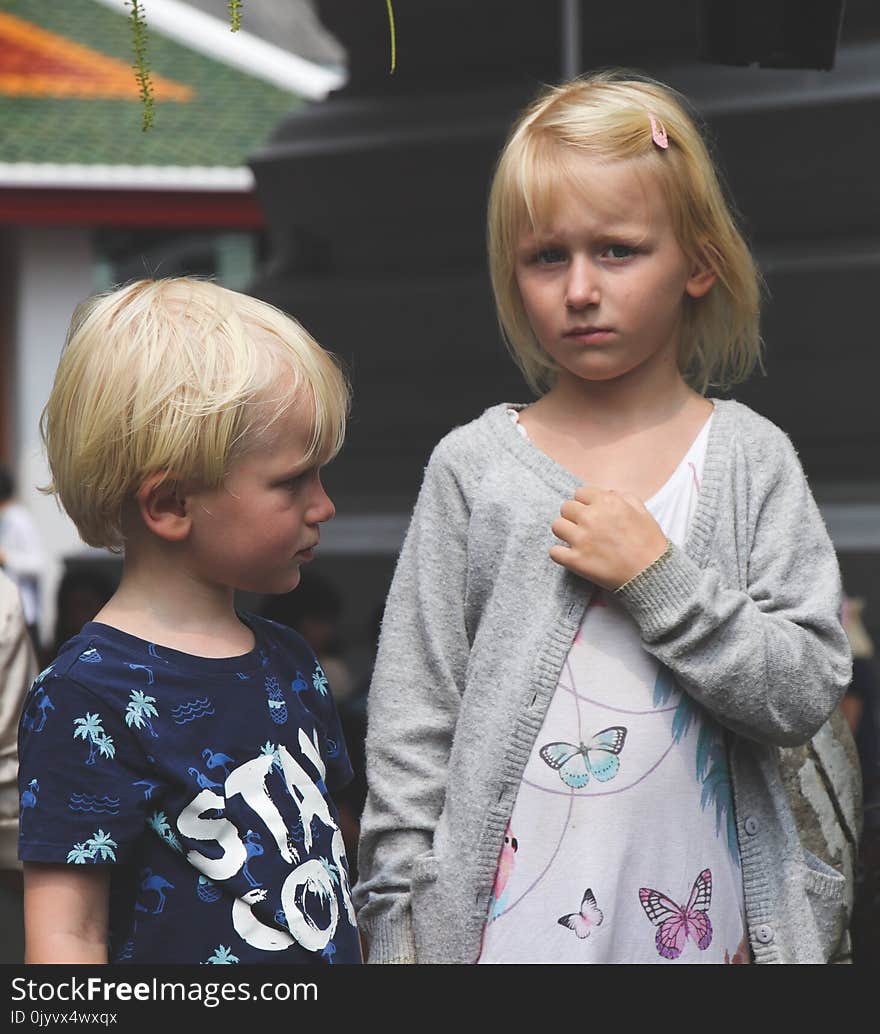 Boy Wearing Blue and White Stay Cool Print Crew-neck T-shirt Next to Girl Wearing White and Teal Butterfly Printed Scoop-neck Shirt and Gray Open Long-sleeved Cardigan