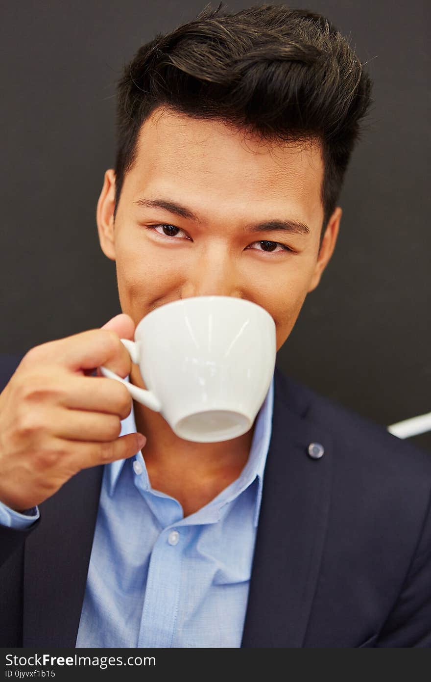 Asian man enjoys break and drinks coffee